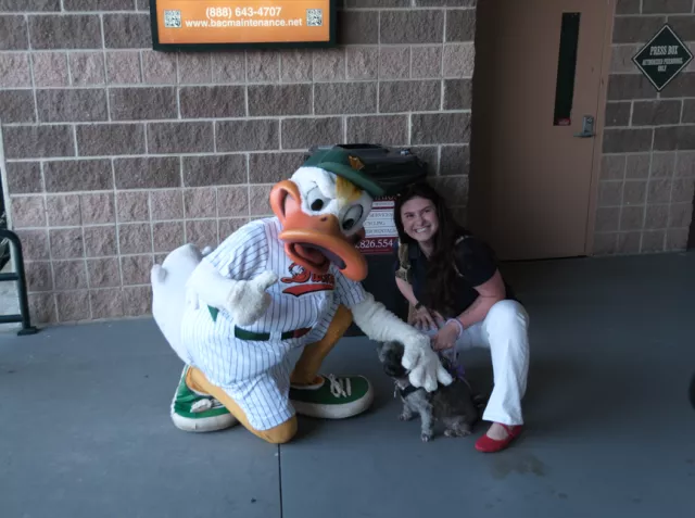 Senior Court Analyst Alexandra Imandt and Stella are greeted by the Long Island Ducks mascot, QuackerJack 