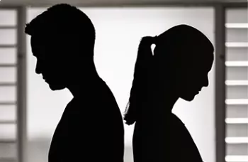 A silhouette of a man and a woman standing back-to-back